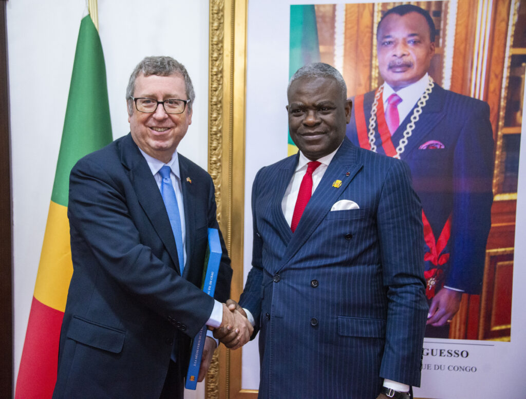 Le Premier Ministre, Chef du Gouvernement, Anatole Collinet MAKOSSO, a accordé une audience à S.E.M Eugène S. Young, Ambassadeur des États-Unis d’Amérique au Congo, venu lui faire ses adieux à l’issue de sa mission diplomatique au Congo.
Lors de cette rencontre, le diplomate américain a exprimé sa gratitude au Premier Ministre pour l’accueil chaleureux dont il a toujours bénéficié, saluant la qualité de la collaboration entretenue avec le Gouvernement congolais tout au long de son mandat.
Les échanges ont permis de revisiter les priorités communes et d’explorer de nouvelles perspectives, notamment dans le domaine du commerce. Les deux parties ont réaffirmé leur souhait de renforcer les relations économiques bilatérales, en insistant sur l’importance d’un climat des affaires propice aux investissements.